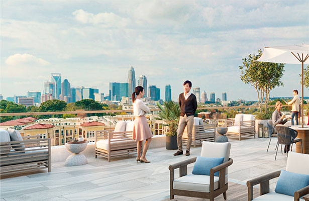 People enjoy a rooftop terrace with views of downtown Charlotte