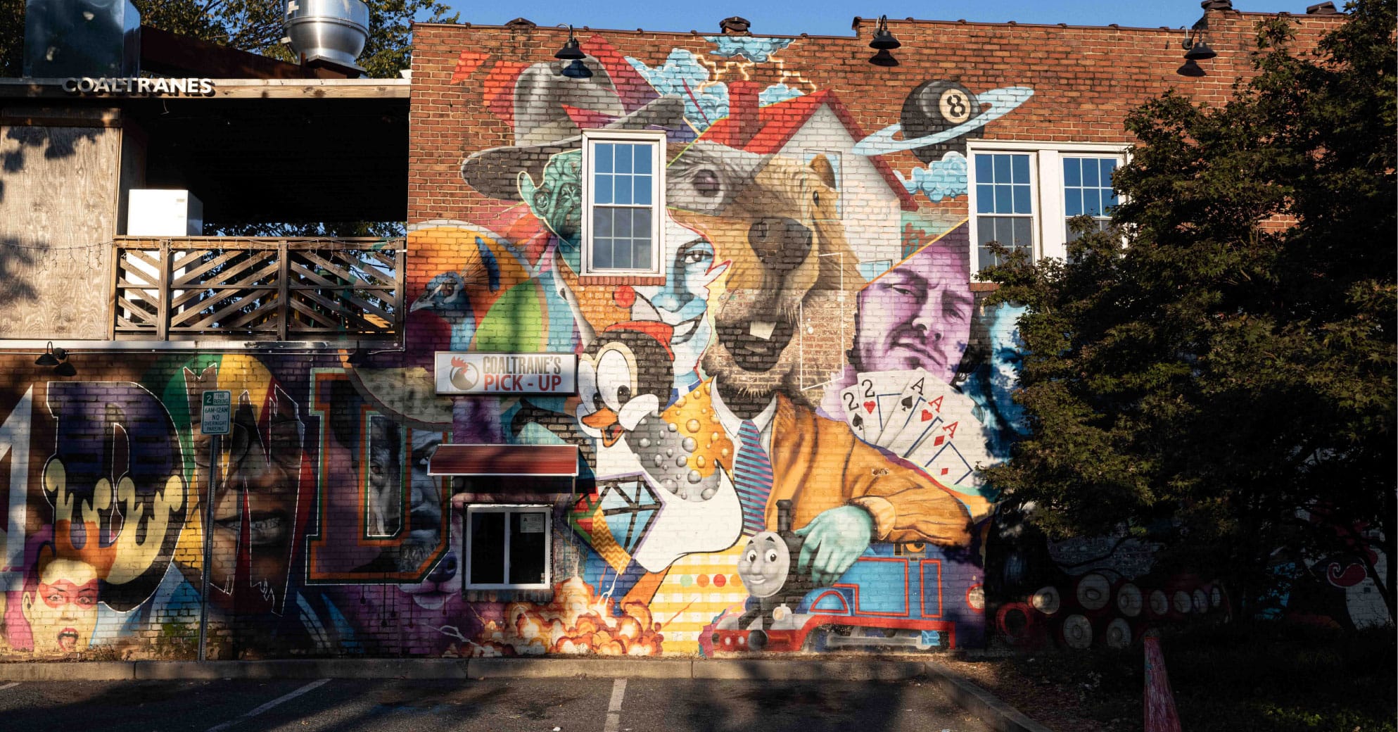 Vibrant mural on brick wall by Coaltrane's restaurant drive-thru window