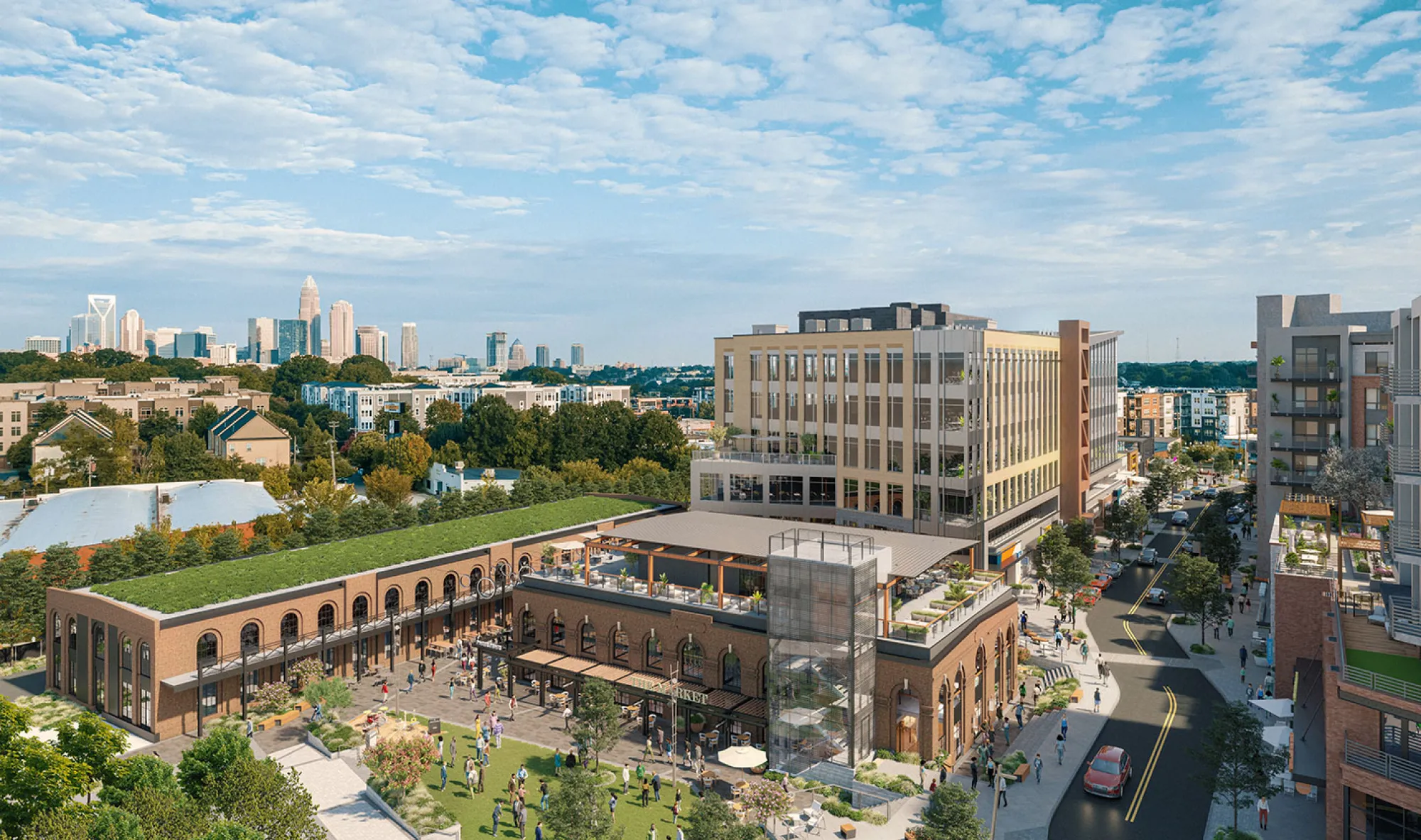 Aerial view of modern mixed-use development with offices, shops, and Charlotte skyline backdrop