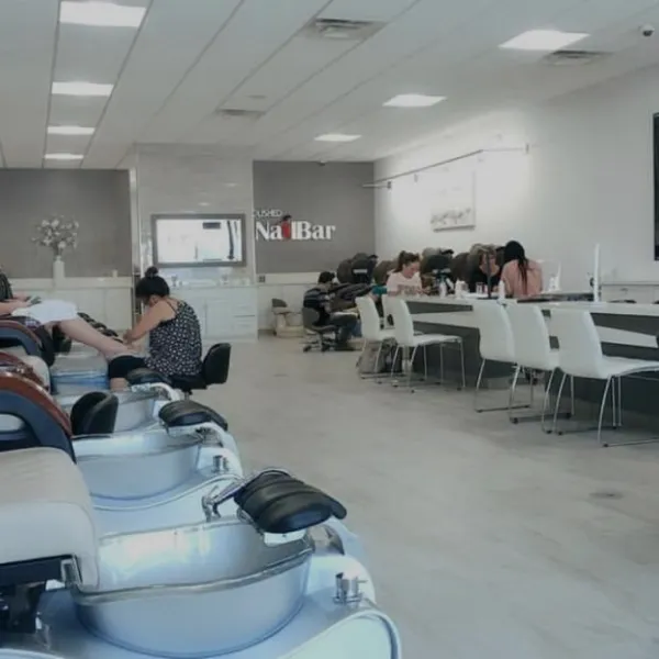 Modern nail salon with pedicure chairs and manicure stations filled with relaxing customers
