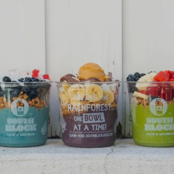 Colorful smoothie bowls topped with fresh fruit and granola from South Block Juice