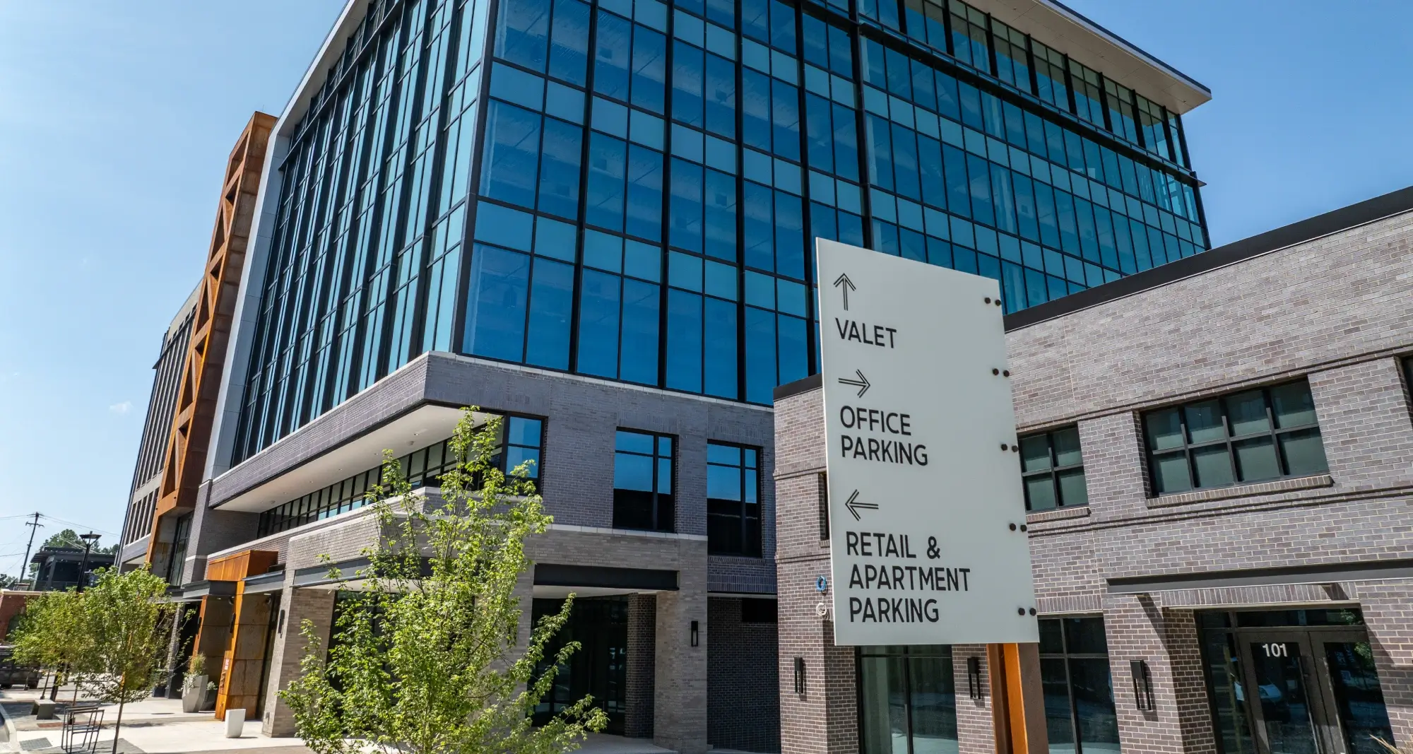 Office leasing sign directs traffic for valet, parking, and retail access at Commonwealth complex