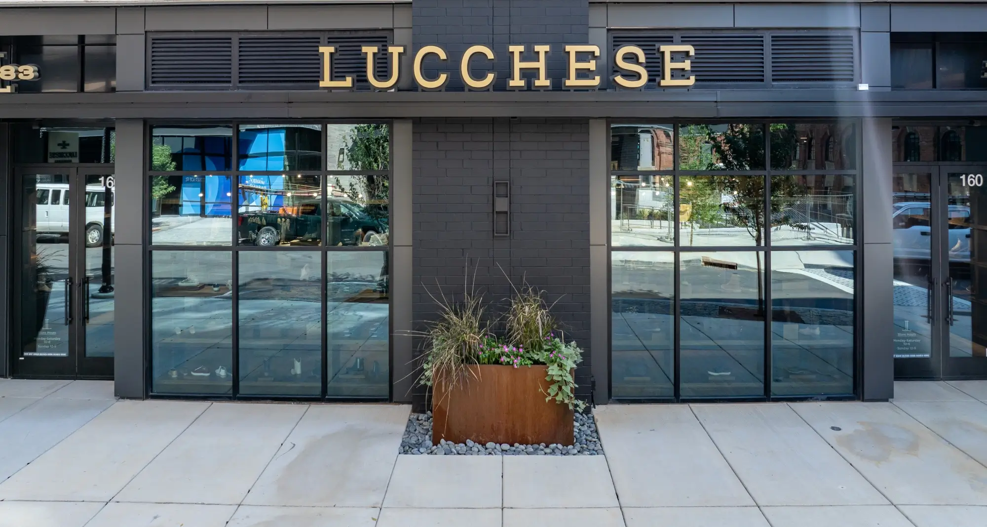 Retail storefront for Lucchese featuring black brick façade and modern industrial windows