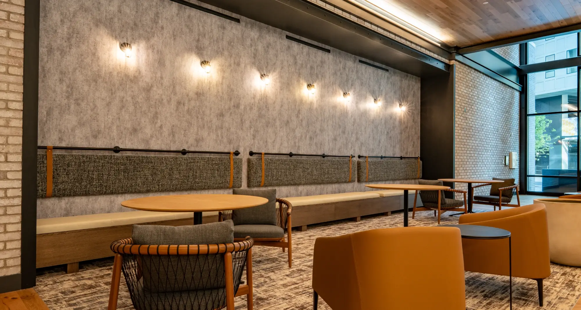 Comfortable seating lounge with wall sconces, soft textures, and warm neutral-toned furniture